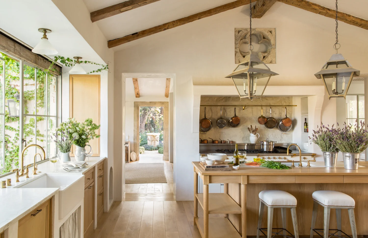 Patina Farm masters the texture game by combing a smooth plaster kitchen hood design with a beautiful stone backsplash. Source: Giannetti Home
