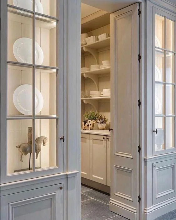 Consider using a pair of glass cabinet doors to flank the entrance to a butler’s pantry. What a pretty statement this arrangement (by Minnie Peters) makes in the hallway.