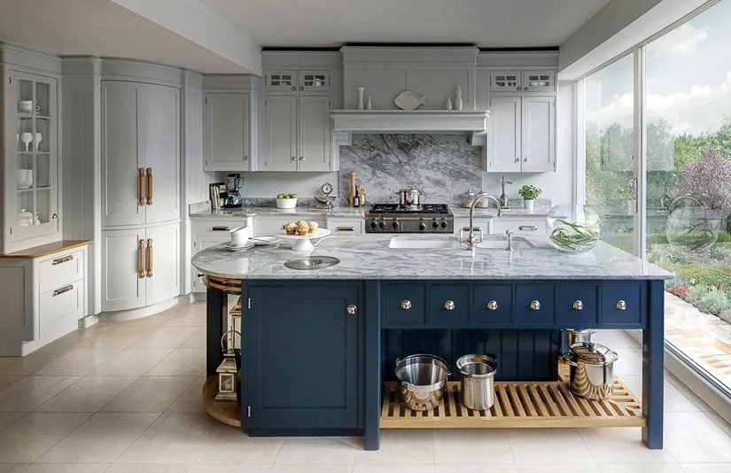 A feature of modern English kitchen design is connectivity to the garden. A single window will not suffice. Instead, entire walls are converted into glass sliders or French doors to allow maximum sunlight and easy access to the outdoors. Design by Mark Wilkinson Furniture