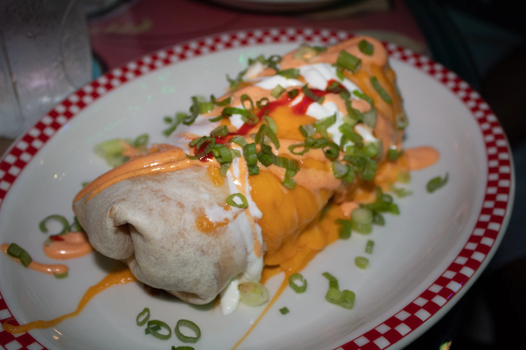 Breakfast Burrito - scrambled eggs, breakfast sausage, crinkle cut fries, cheddar, sriracha aioli, and scallions