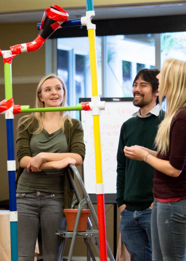 Two men and two women test their marble works team building creation