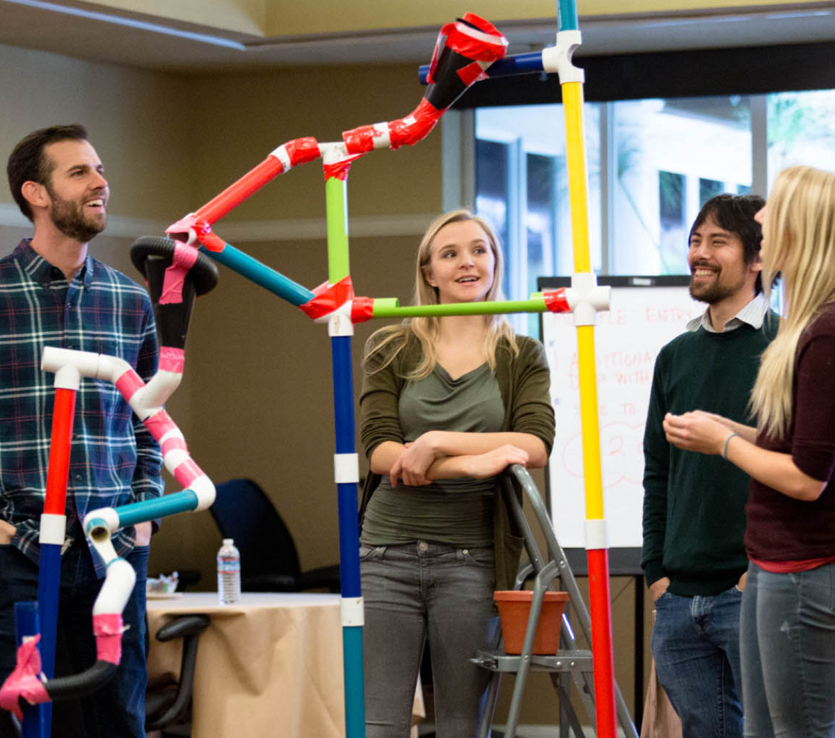 Two men and two women test their marble works team building creation