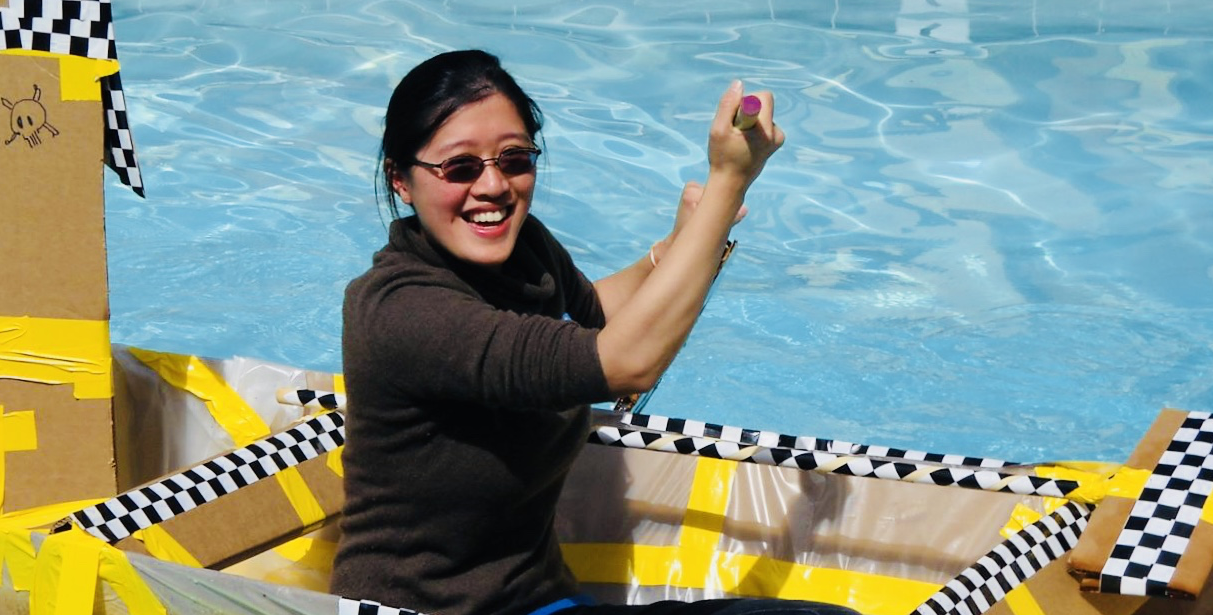 A woman tests a boat built during a team building exercise