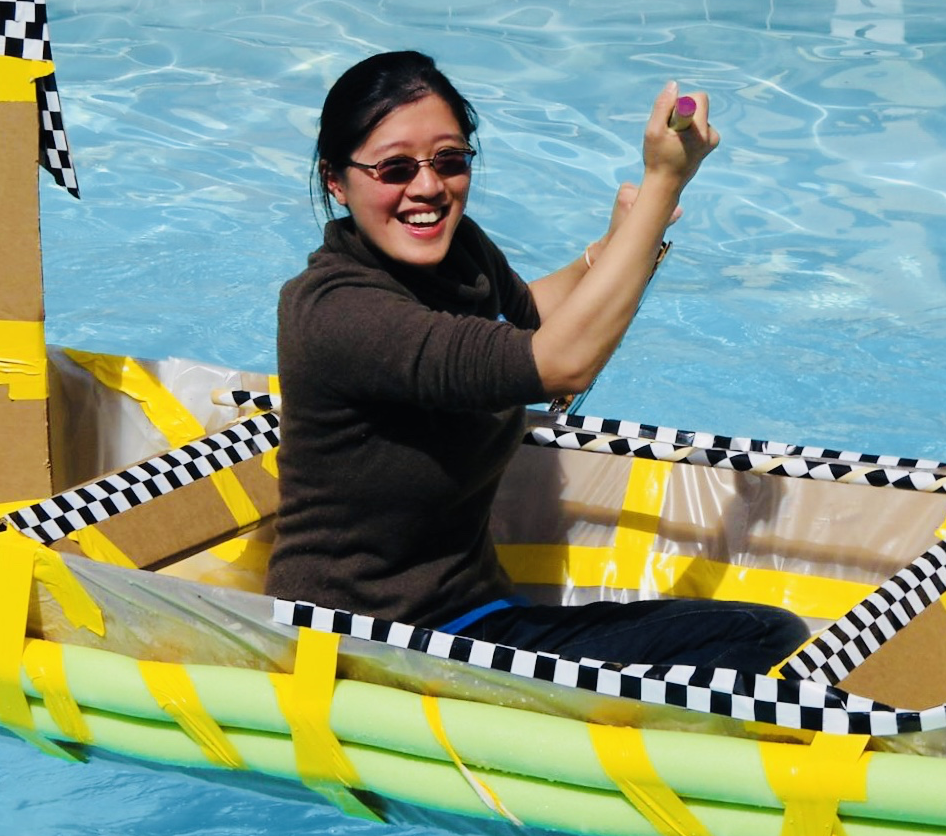 A woman tests a boat built during a team building exercise