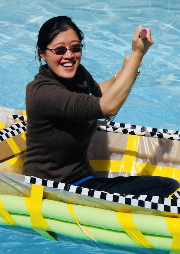 A woman tests a boat built during a team building exercise