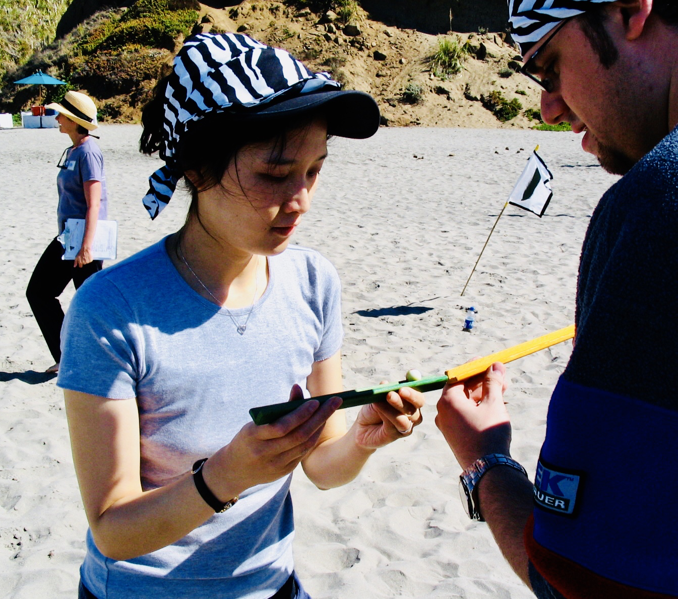 A woman analyzes a clue during a team building event on the beach