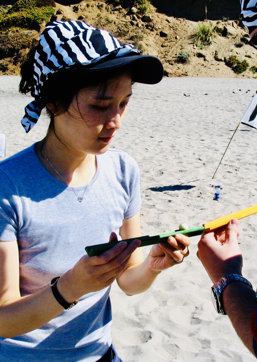 A woman analyzes a clue during a team building event on the beach