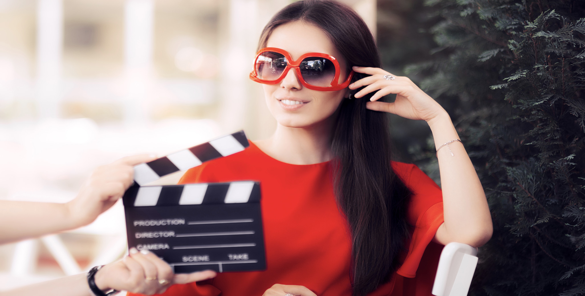 An actress prepares to shoot a scene as a stage hand holds the clapperboard.