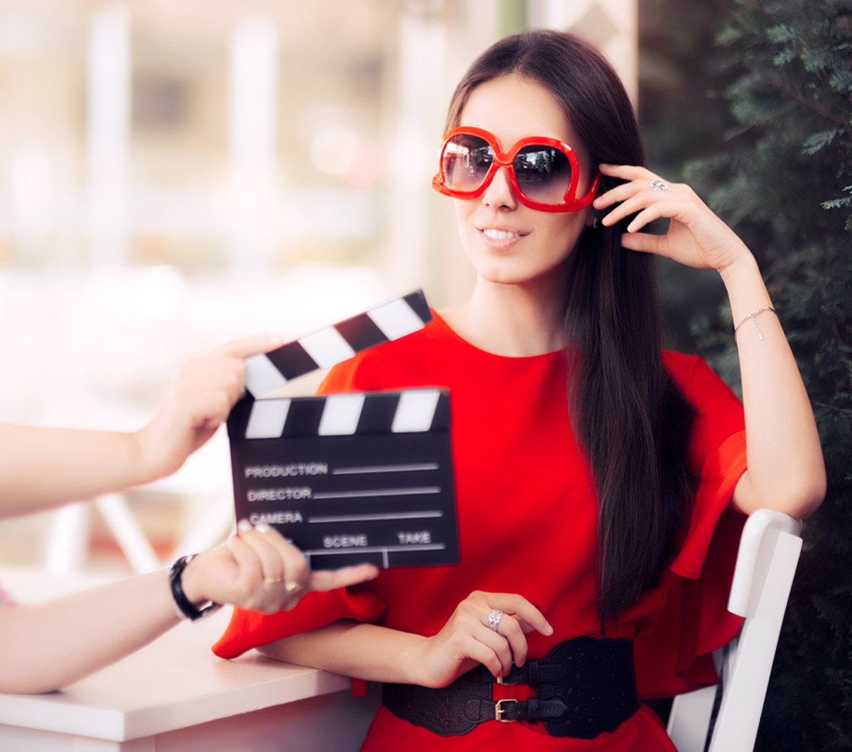 An actress prepares to shoot a scene as a stage hand holds the clapperboard.