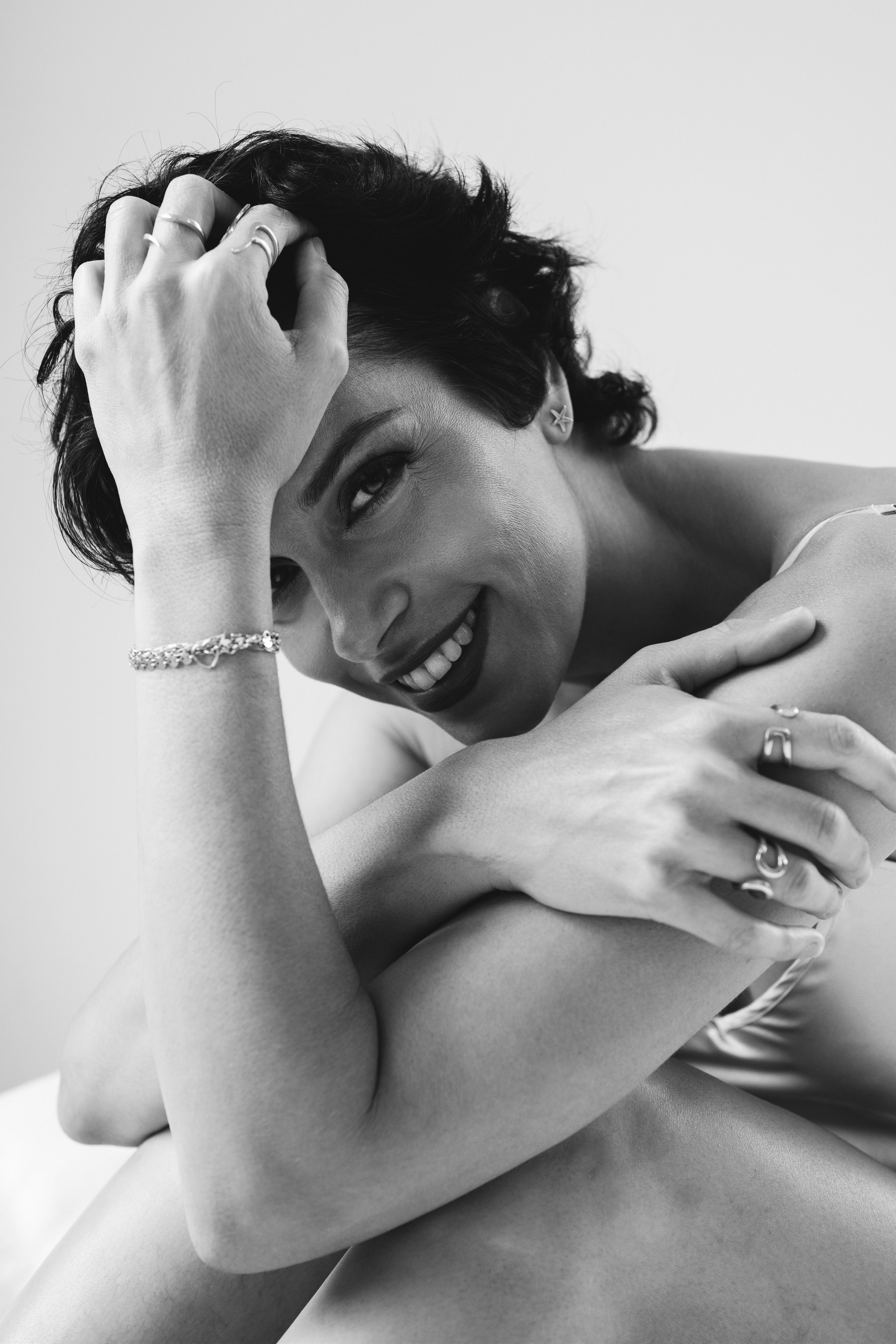 A quiet, intimate portrait of a woman at ease with herself. Her posture is soft, her expression open, carrying a sense of warmth and self-trust. Nothing is forced. Nothing is hidden. The image feels personal, grounded, and deeply human.