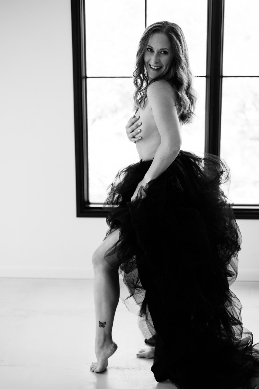 Boudoir woman no top and tulle skirt, monochrome