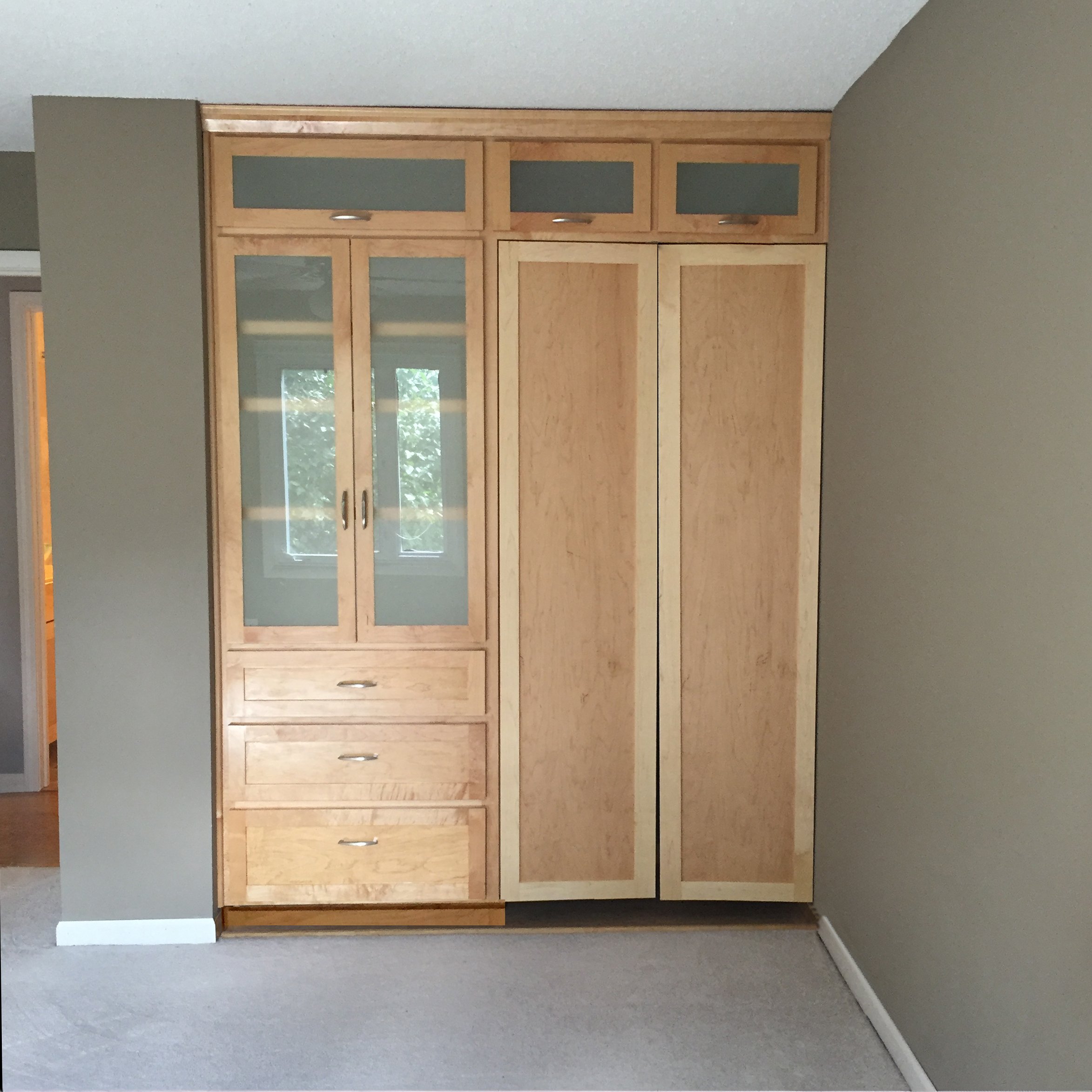 Custom Bedroom Built-in Closet with storage area at the very top, room for hanging clothing, drawers, and open cabinet feature.