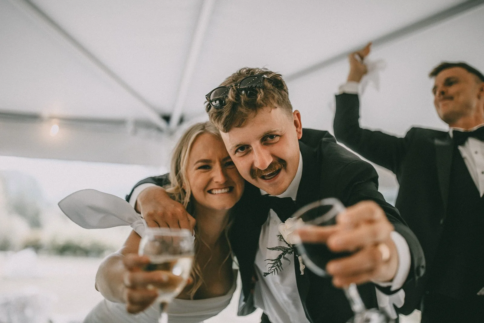 People in formal attire celebrating with drinks, smiling, and enjoying a party.