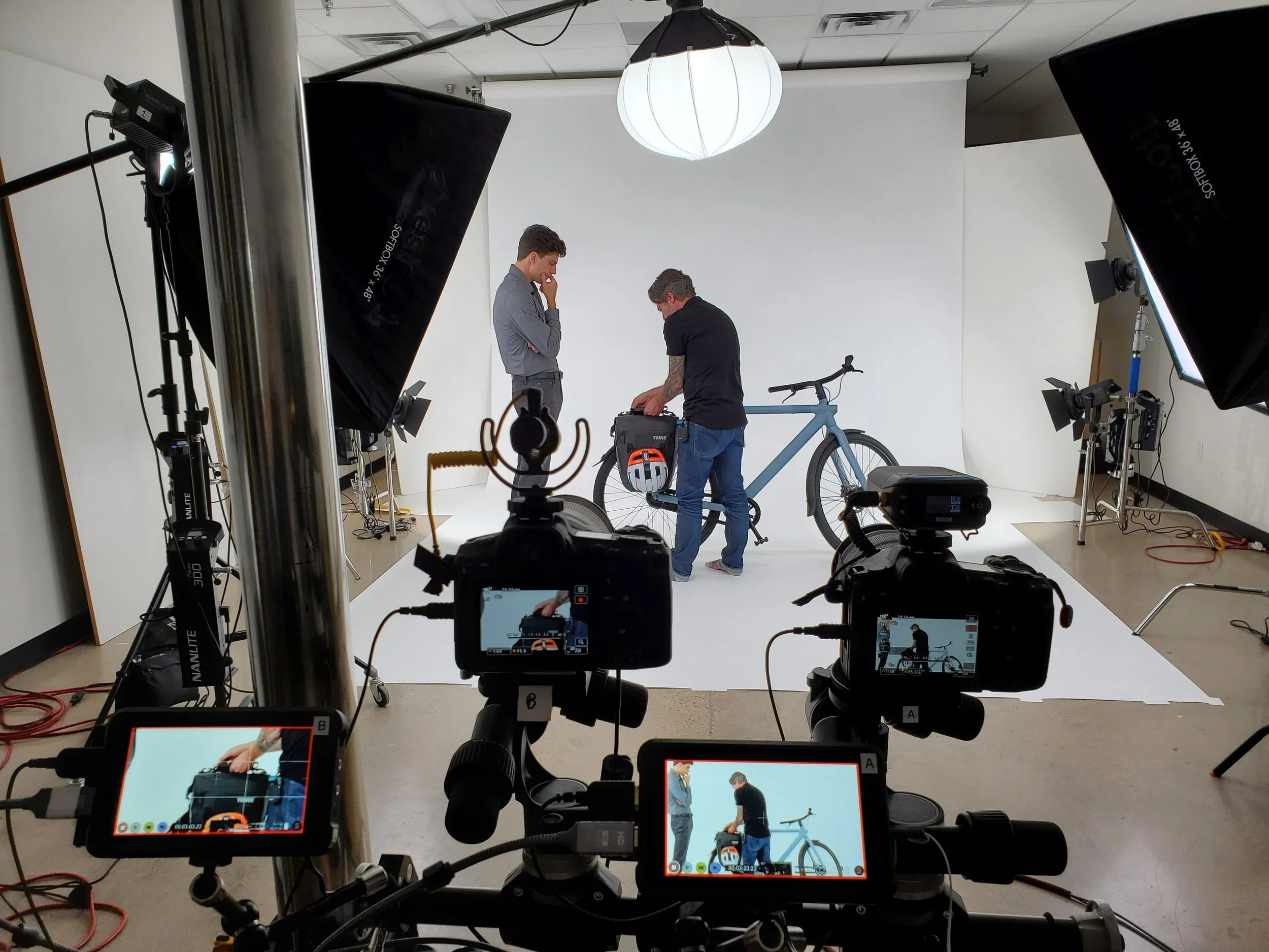 Video production behind the scenes with cameras, monitors, lighting, and products in a studio setting to emphasize educational, product, and event based content. Trust building video content.