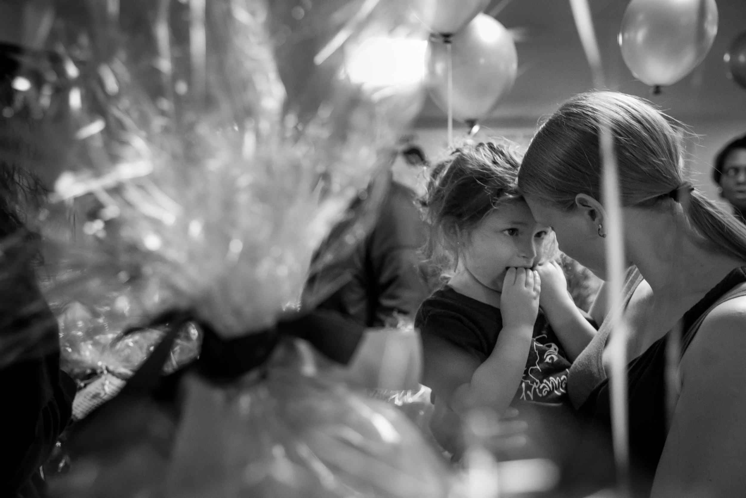 A family friend carries Arianna during a benefit held to raise money for a service dog for Arianna. Her family depends on state health insurance to pay for her treatment and rehabilitation, but it doesn't cover everything that they hope to give her to support her growth and development.