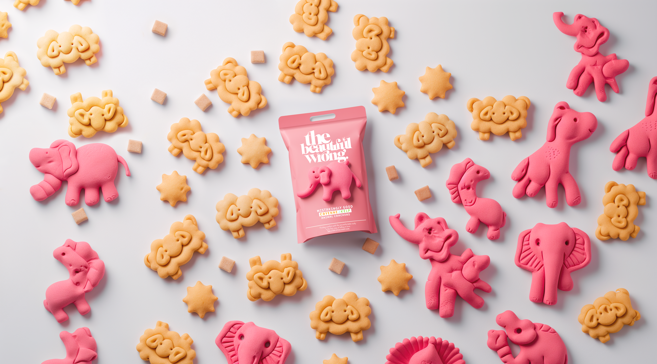 assorted pink elephant, lion, and horse shaped animal crackers and small beige square crackers scattered around a pink package labeled "the beautiful wong" on a white background
