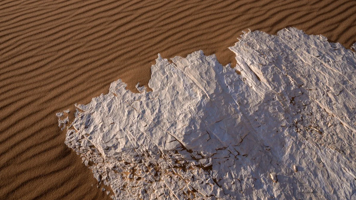 White chalk meets rippled golden sand in Egypt’s White Desert, capturing contrasting textures and natural patterns through Dany Eid’s lens