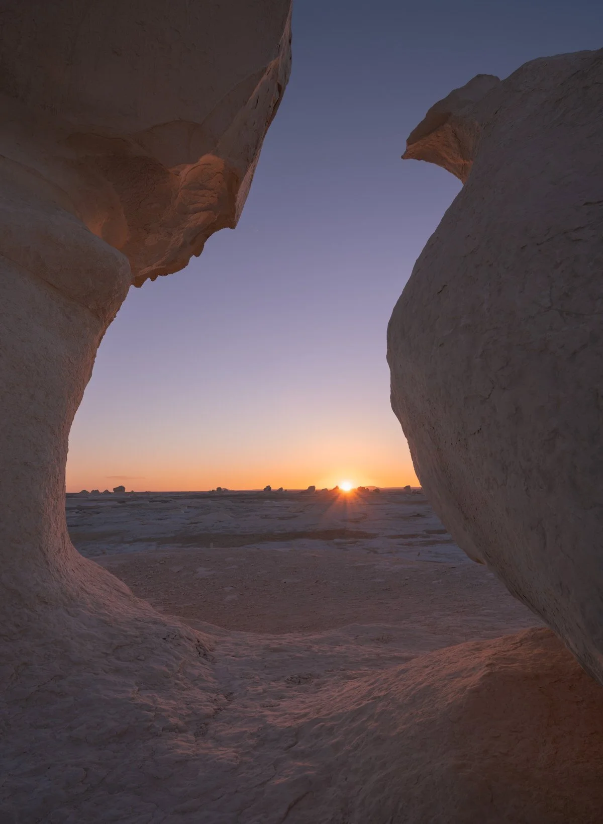 Golden sunlight framed by towering chalk formations in Egypt’s White Desert, captured by Dany Eid in a moment of desert stillness