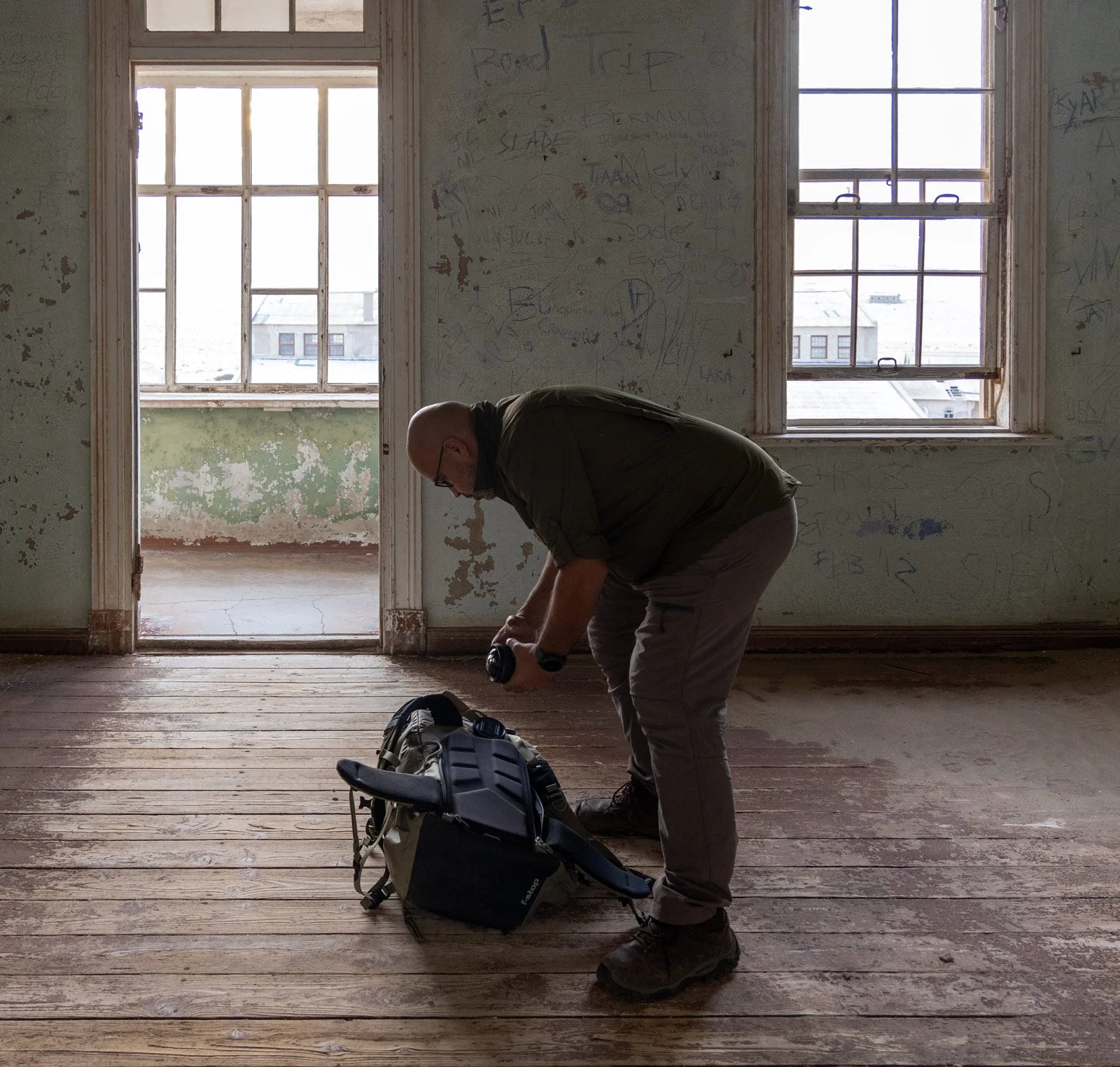 Dany Eid preparing camera equipment inside an abandoned building at Kolmanskop, Namibia.