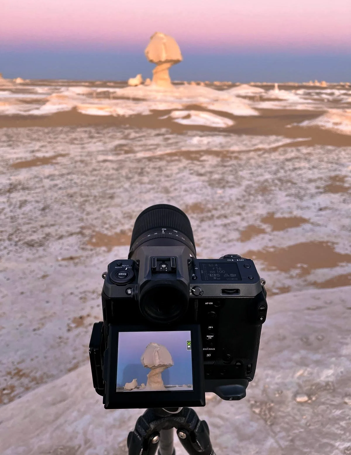 A Fujifilm camera frames the mushroom-shaped chalk formation beneath a pink sky in Egypt’s White Desert, behind the scenes with Dany Eid