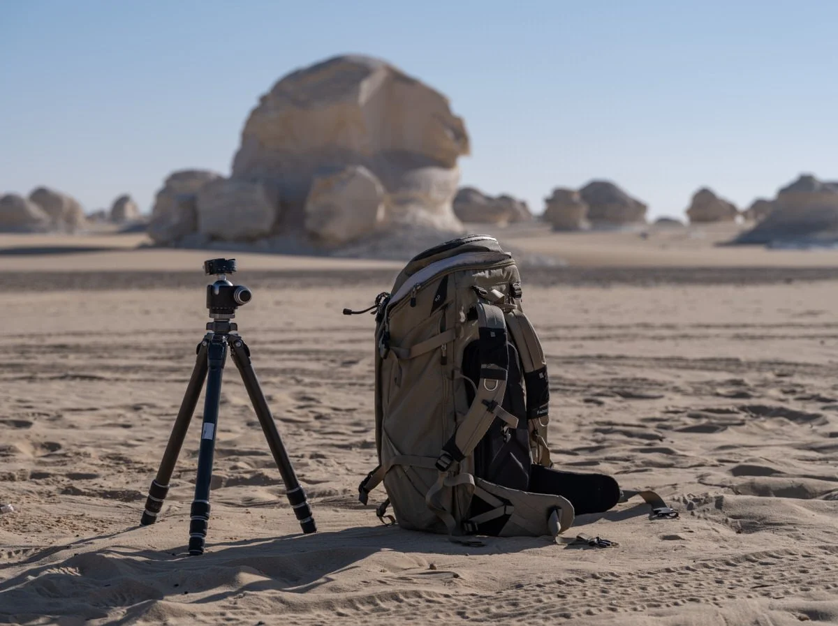 A tripod and camera backpack stand among Egypt’s White Desert chalk formations, ready for Dany Eid’s landscape photography adventure