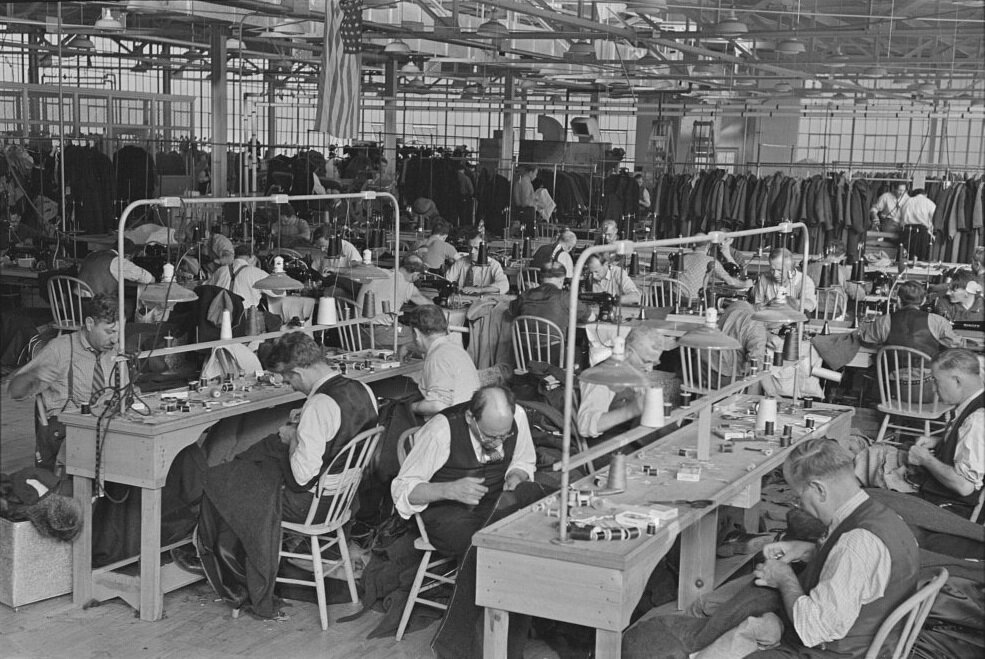 Interior of cooperative garment factory at Jersey Homesteads, showing some of eighty homesteaders at their work and some of the ladies’ coats made by them, November 1936