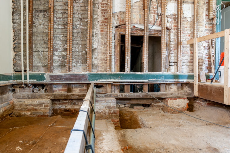 The original door opening to the cellar is now visible. The connection between the stair tower and the 1729 addition can be clearly delineated in the color of the now exposed brick.