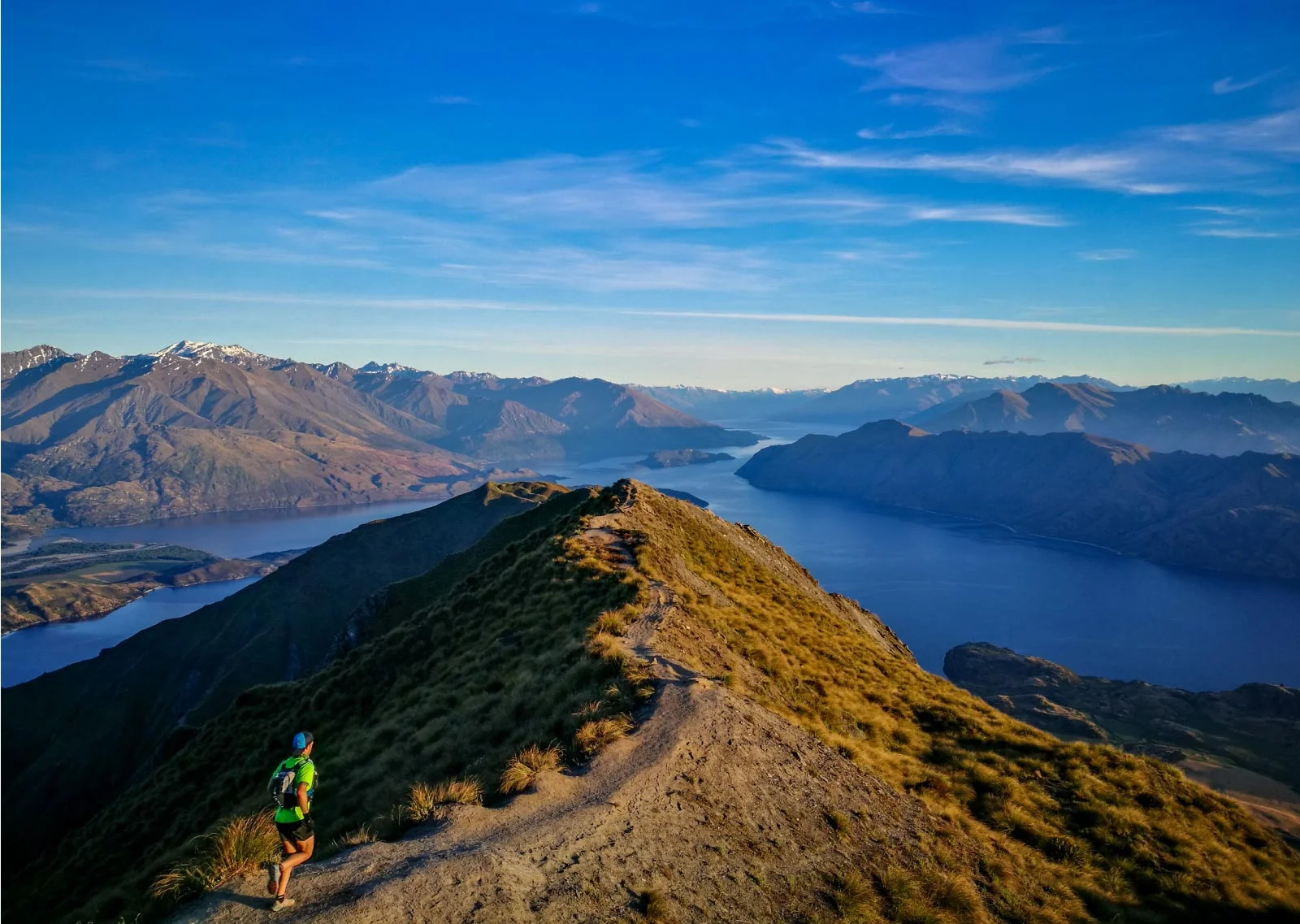 The Classic trail running tour takes in the best of what Queenstown, Wanaka and the surrounding area has to offer. The Classic combines one full day mountain run plus two half day runs, and a couple of optional extras. We explore the Oteake Conservation Park, wrestle with Roys Peak and battle with Ben Lomond in Queenstown. Those eager enough also have the chance at some optional extras, including a recovery run or ride on some of the scenic Central Otago Rail Trail, a sunset run up Queenstown Hill, plenty of exploration to soak it all in and self selected recreation time that could include anything from luge rides to downhill mountain biking. We will cover approximately 60-70km over the tour and around 3000m+ of elevation, all sandwiched between arrival and departure days either side. Difficulty The terrain and distances are sure to challenge, so you do need to take note of distances, terrain types and your fitness levels. However, our style remains holiday-esque, so don’t bring your game face except when facing the mountain itself. RunAways are holidays tours. We encourage anyone with the stamina to join our tours. While our tours may be physically very demanding, speed is irrelevant and we are non-competitive. This isn’t a training camp, it’s a holiday, just like no other! If you have any questions about your fitness, please get in touch. Itinerary Summary Day 1 | Arrival: Start with our first meet up at Queenstown Airport. Meet team and tour briefing. Day 2 | Oteake Conservation Park: A big day to start the tour, with around 30km-35km to shake of any laggy travel legs. Meals offered: Continental breakfast option Day 3 | Recovery: Optional recovery run or ride on parts of the Central Otago Rail Trail and time to soak in some of the sights of stunning Wanaka. Meals offered: continental breakfast option Day 4 | Roys Peak: Tackle this standout classic after an early start. The goal is a sunrise summit, and a delicious post run meal of course! Meals: continental breakfast option Day 5 | Travel & Queenstown Hill Hike: Today we travel, with an option later in the day for a hike up Queenstown Hill to keep those legs moving. Queenstown is our final destination and tonight we prep for our final push tomorrow morning. Meals: continental breakfast option Day 6 | Ben Lomond: The iconic Ben Lomond ascent right at the doorstep of Queenstown. Followed up with an afternoon of leisure and celebratory dinner at the Skyline Gondola buffet (at own expense – optional) Meals: continental breakfast option Day 7 | Tour End. Group bus available for drop offs at Queenstown Airport or for those staying on in Queenstown, their nearby accommodation. Meals: continental breakfast option Inclusions: Airport pick up & drop off. Department of Conservation Permits Guided Runs Guided recovery and flexibility session Accommodation Travel within New Zealand with the RunAways group. Some breakfast/meal options (Bread, spreads, cereals, milk, coffee and tea) and snacks (some fruit, muesli bars). Two spirited, experienced & passionate runners as guides. Exclusions: Costs of any optional recreation activities, including any hire of equipment, entry fees or contracting third parties for services. Food and meals outside of the provisions mentioned in Inclusions. Individual optional travel outside of group activities and local area transfers. Flights not included Please note: We have done our utmost to ensure all material published on this web page is accurate and up to date. However, any and all actual tour details can be updated from time to time. Final confirmation of any details must be made direct with the organisors and are reflected in the Administration Pack.