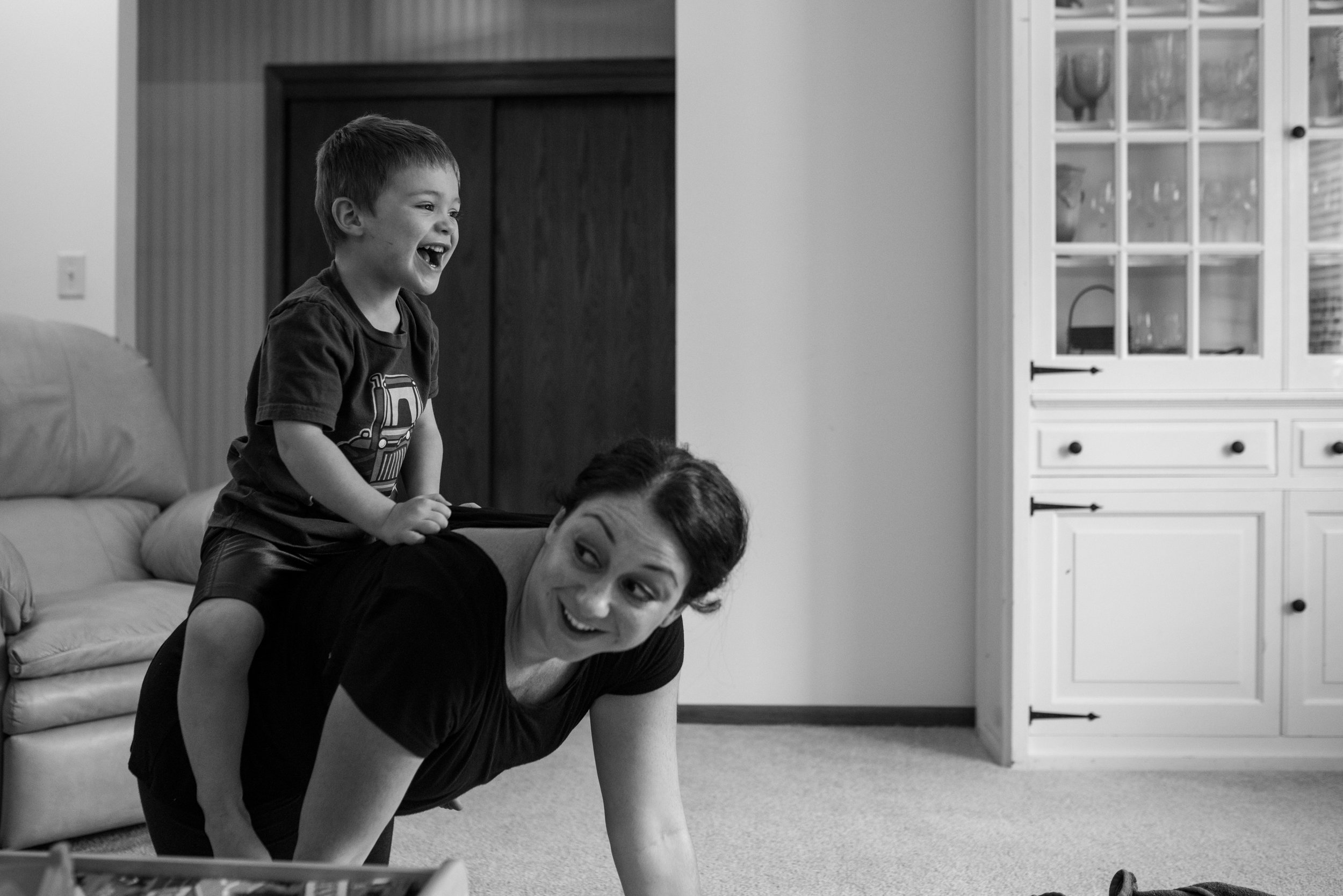 Son riding on moms back and laughing