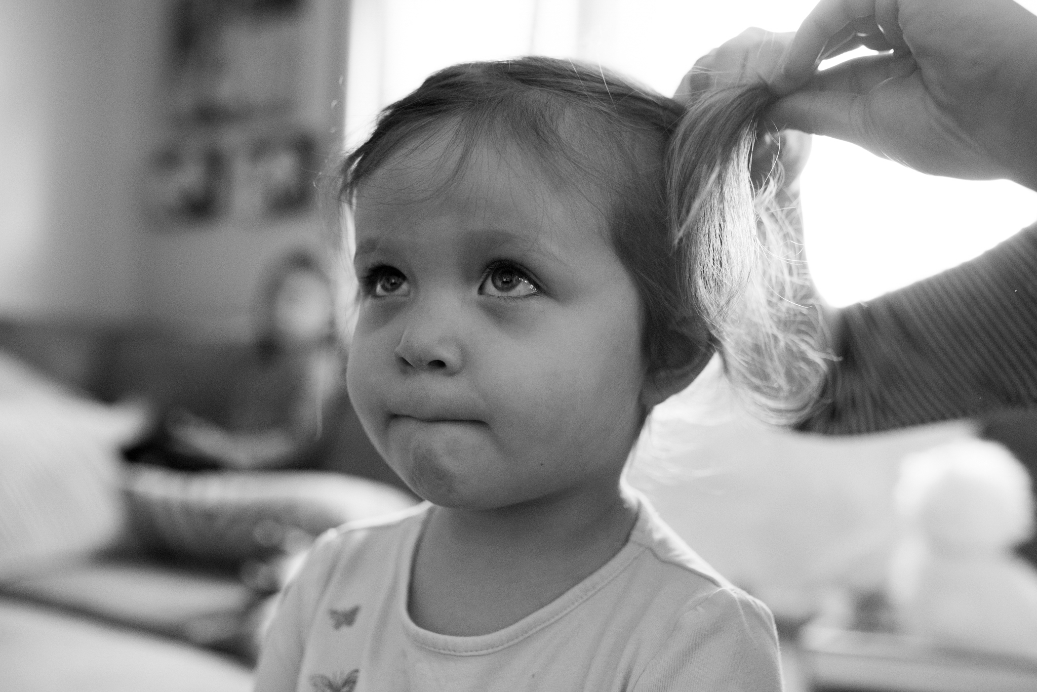 Young girl getting pig tails put in her hair