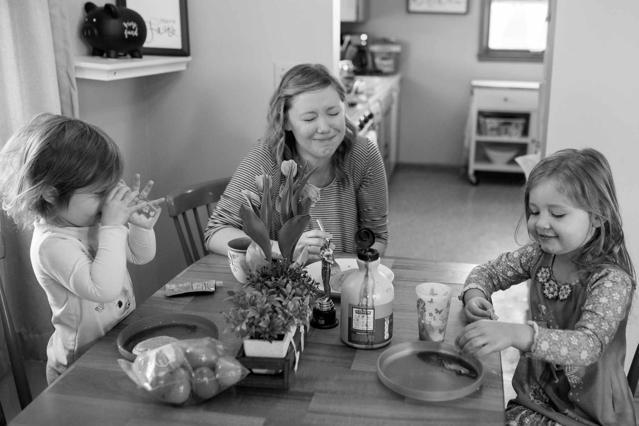 Mom and daughters at kitchen table, mom laughing