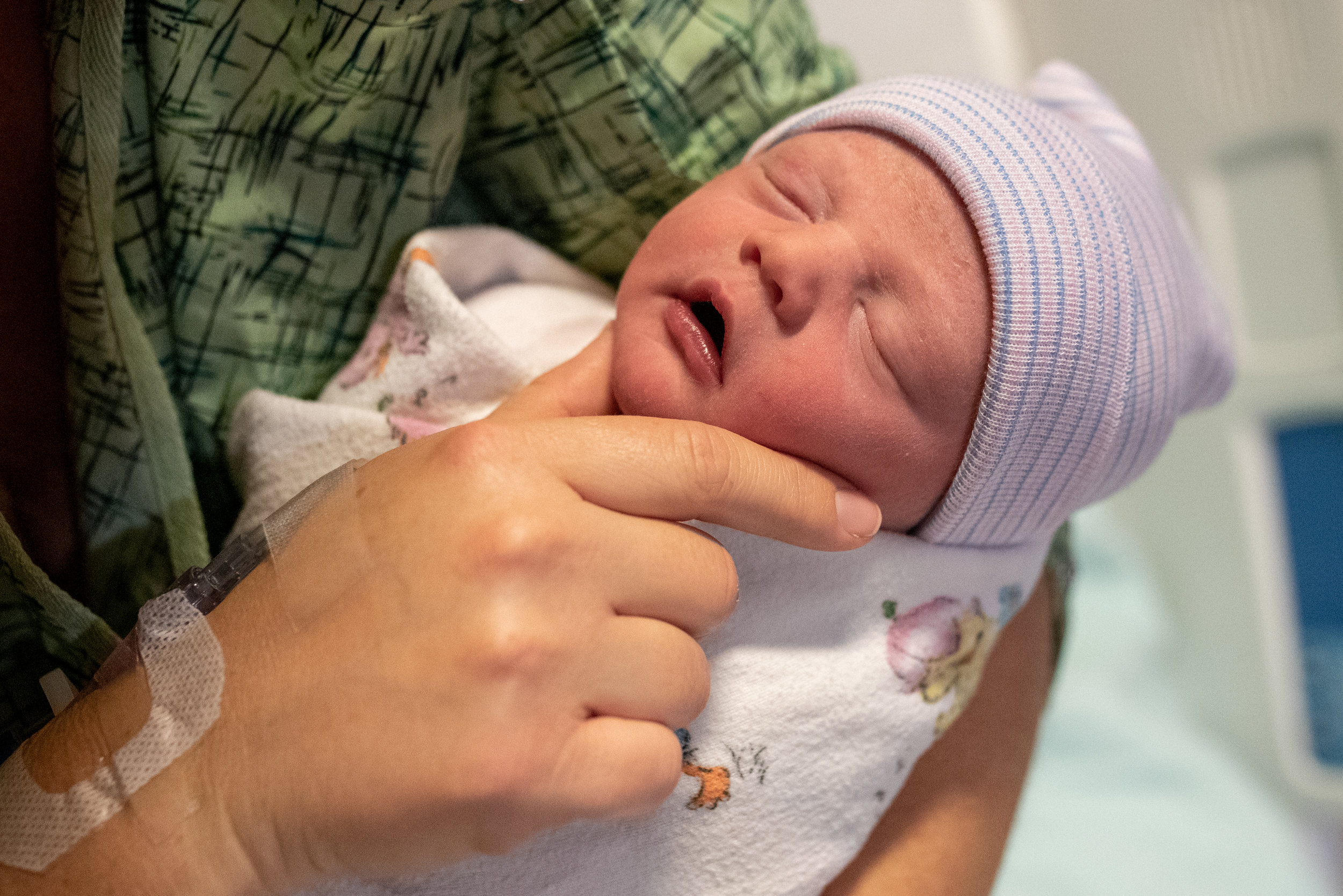 Mom touching newborn babies face in the hospital