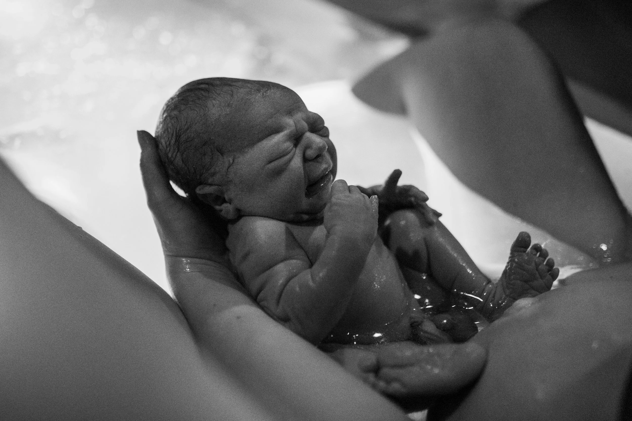 newborn baby in tub with mom after delivery