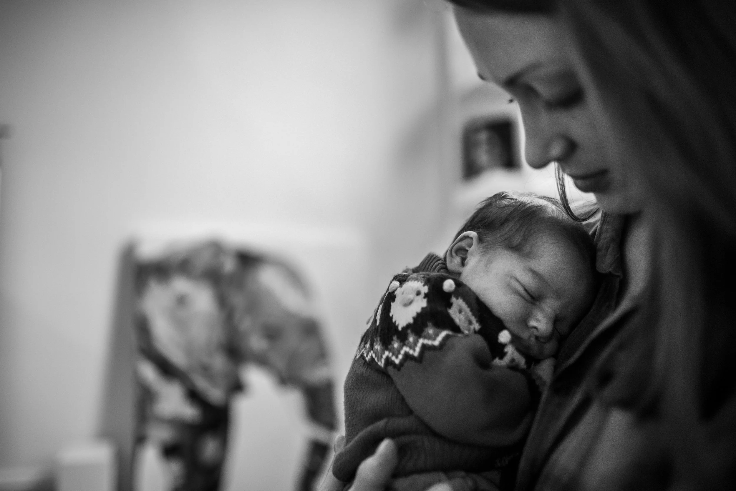 Newborn baby snuggling against moms chest and sleeping