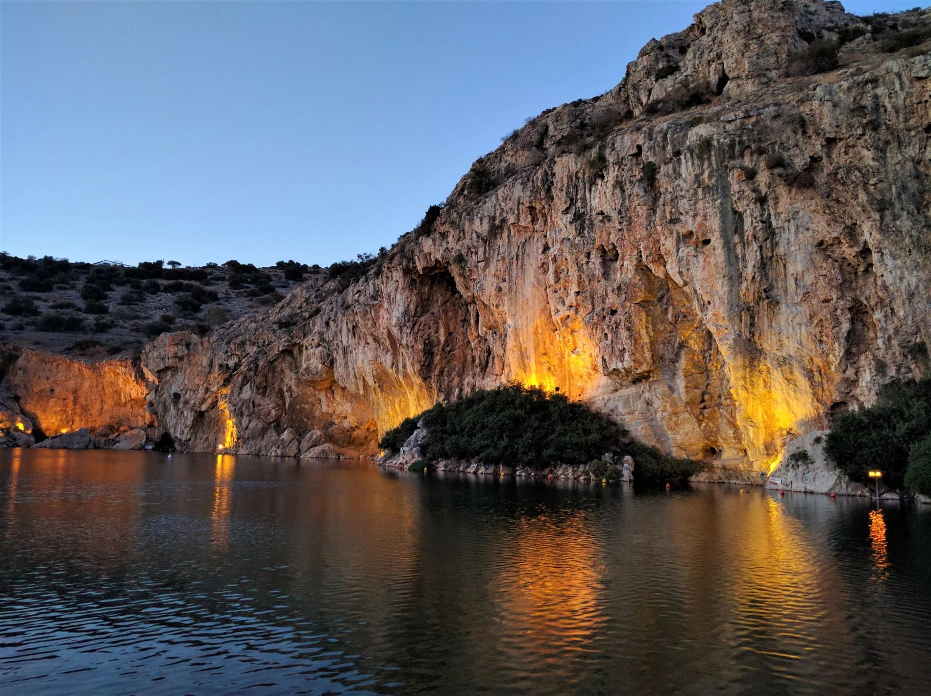 Lake Vouliagmeni at dusk. The lights make the rock formations even more dramatic at night.