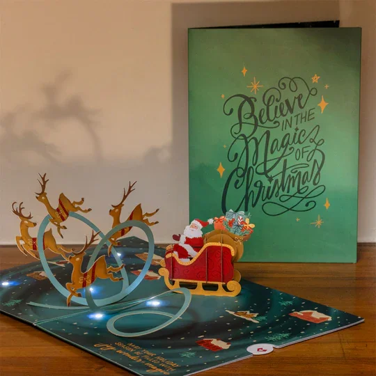 LP5793_MagicofChristmasSanta_sSleighLight-UpPop-UpCard_Lifestyle_386483e0-d063-4a09-82e2-09d9bc71f78a.webp