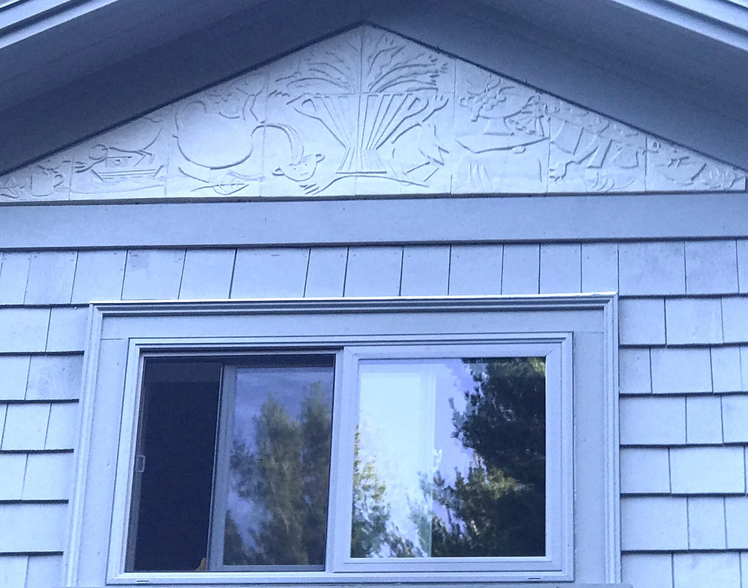 This is an early morning photo of a new porcelain pediment that was just installed yesterday on our new addition. The piece is carved porcelain, @ 7 ft at the base. Decorative and functional wood trim will be applied to the border shortly. We thought about all types of finishes for the piece such as multi-colored images to Wedgwood figure/ground solutions and settled on simple bas-relief. One nice thing about the piece is how it is very subtle. It is on the second floor, pretty high up. It is integrated nicely with the house without calling too much attention to itself. The imagery comes from Francine's work: the laundry line, boat, flowers, ceramics, piled rocks and, of course, busy birds. The piece will look different in every season. I think it will be most dramatic when the sun is lower (winter) and in fall and spring. With the sun being so high in the summer, a lot of shadow falls over the piece from the generous overhang. We will post other pictures at different times of year to see if this is true. It was enormously fun to do. We will see how it lasts through our weather.