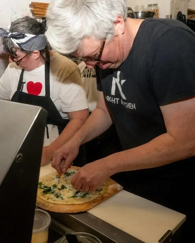 Night Kitchen team preparing a pizza together