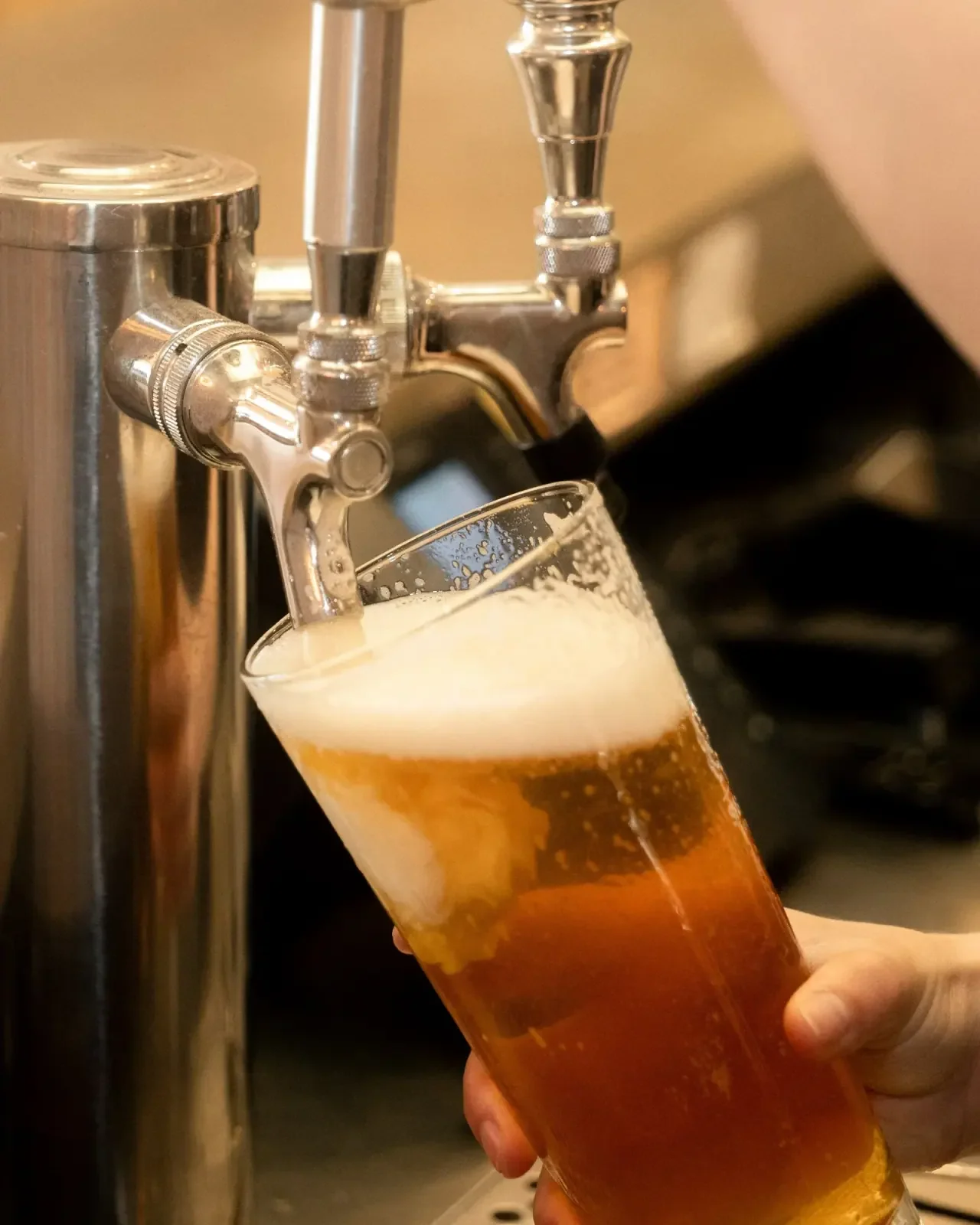 Draft beer pouring from a tap into a glass at Night Kitchen.