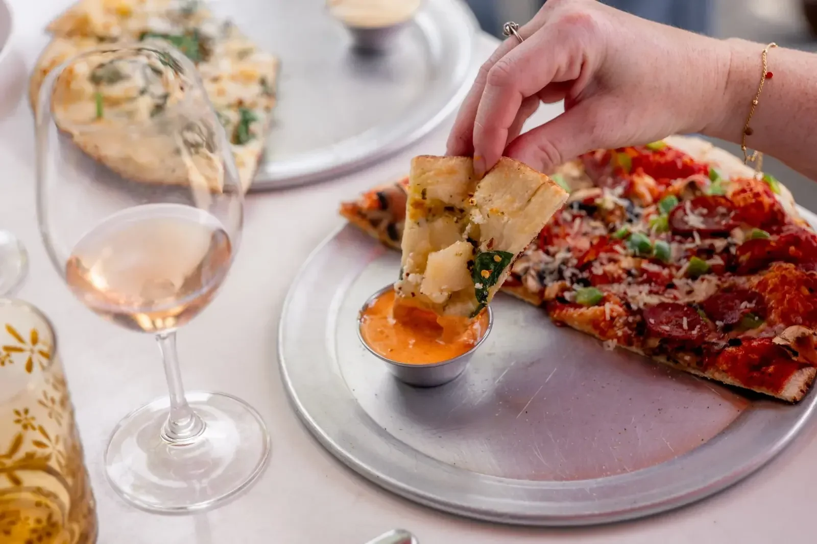 A piece of pizza crust dipped in Night Kitchen house-made chipotle aioli.