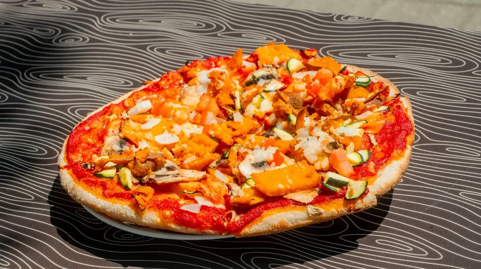 Vegan pizza with tomato sauce and vegetables at Night Kitchen