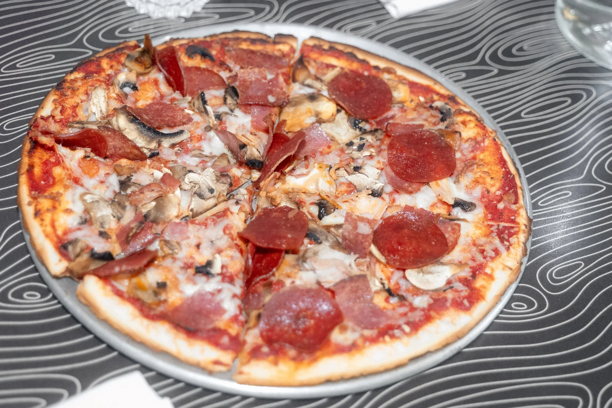 Meatza pizza with sliced meats and mushrooms at Night Kitchen