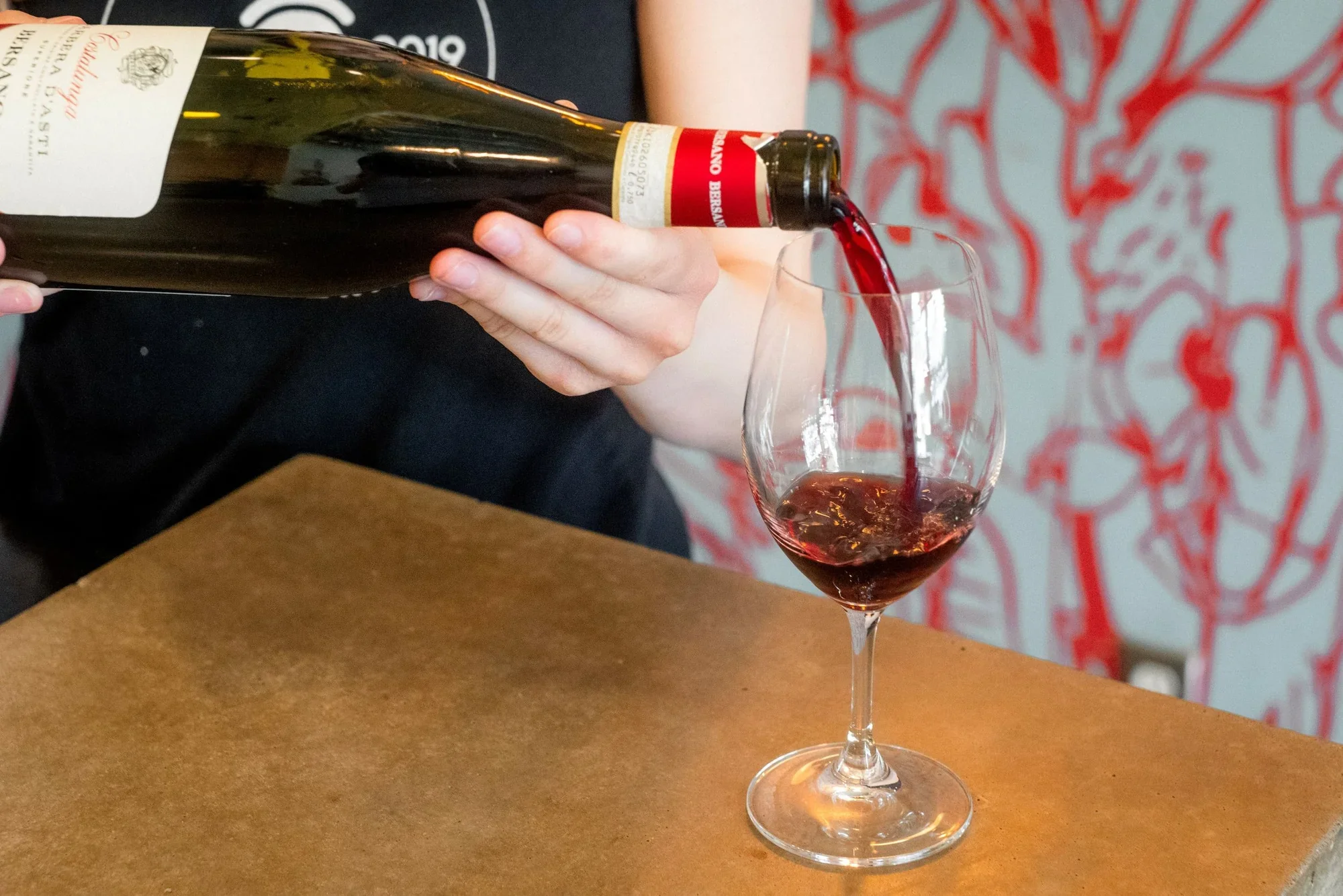 Red wine being poured into a glass at Night Kitchen.