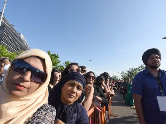 Standing behind pens erected in the MetLife Stadium parking lot, fans wait to see celebrities. Photo: Viorel Florescu/NorthJersey.com