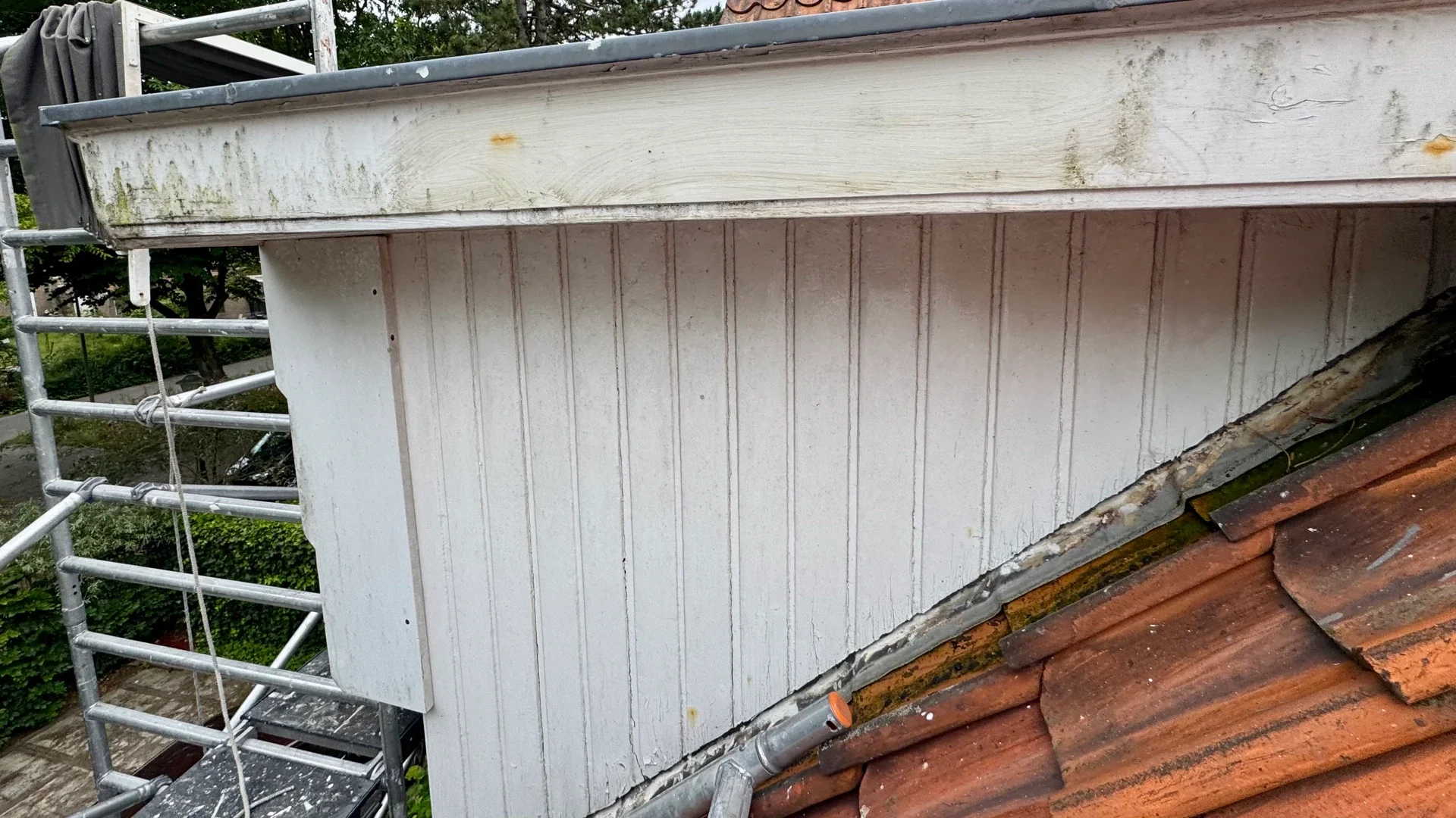 Vervuild en verweerd houten buitenwerk aan woning in Bentveld
