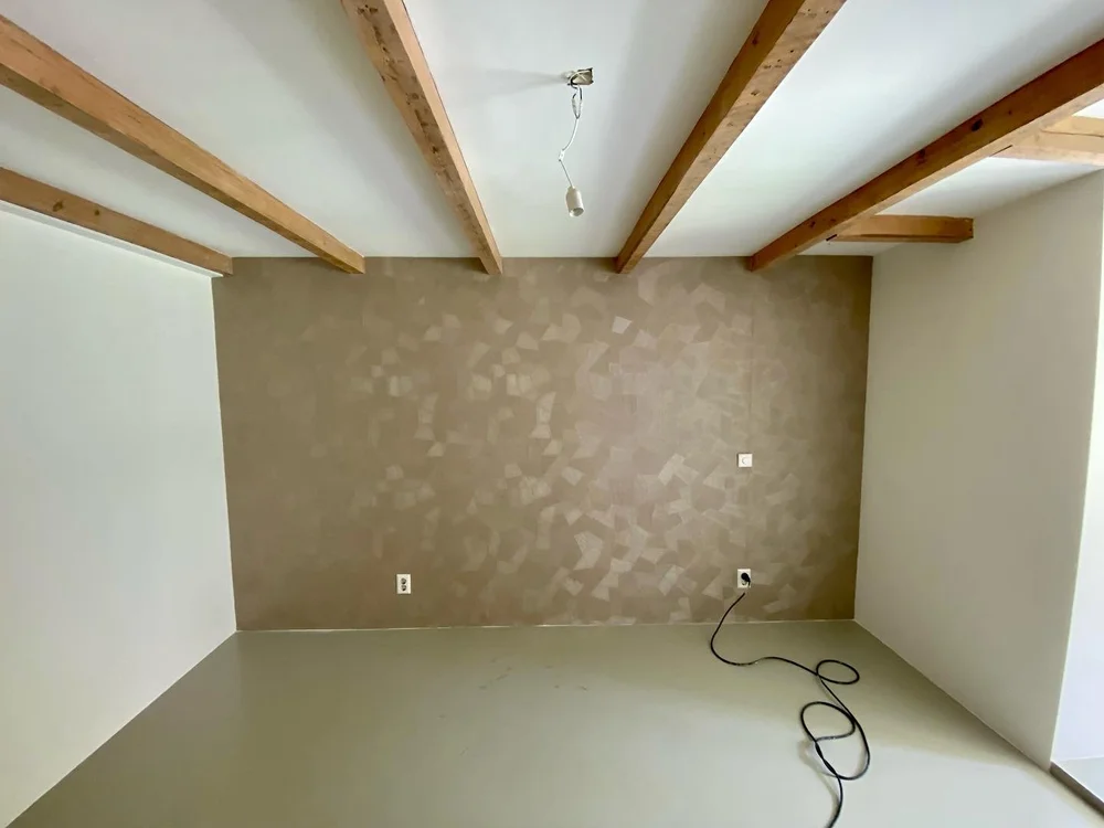 Strak afgewerkte wand met behang en houten balken