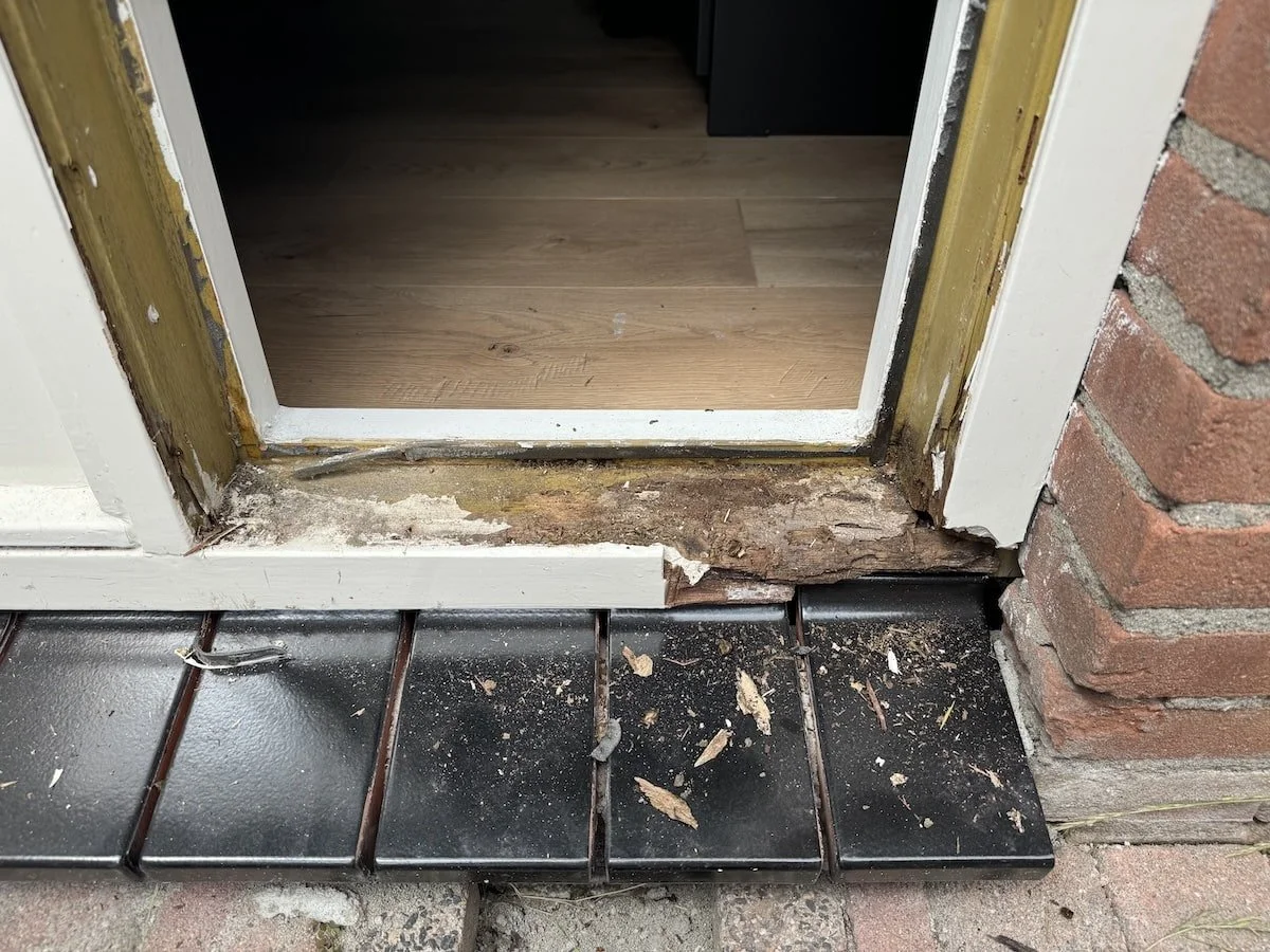 Houtrot in kozijn – herstel door Schildersbedrijf E.G.M. Asseler & Zoon. Vocht en schimmels hebben het hout aangetast, aangetaste delen worden verwijderd en professioneel gerepareerd.