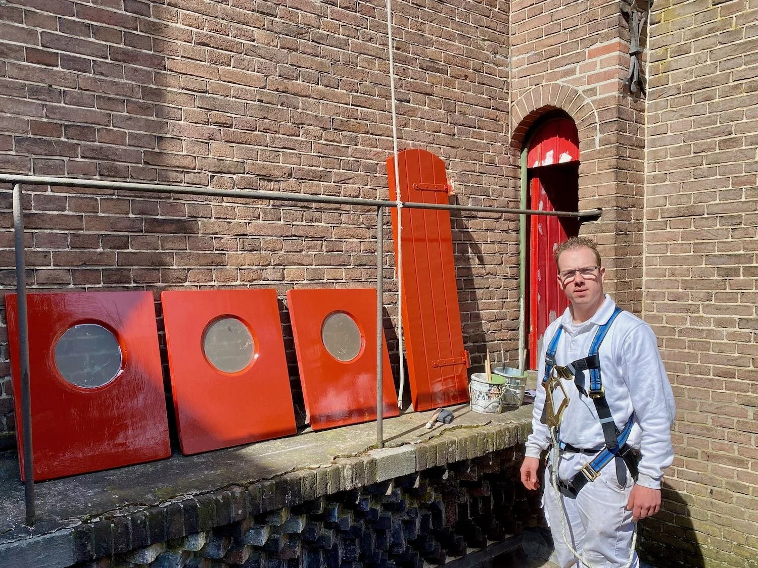 Dave Asseler schildert kleine deuren in de kerktoren