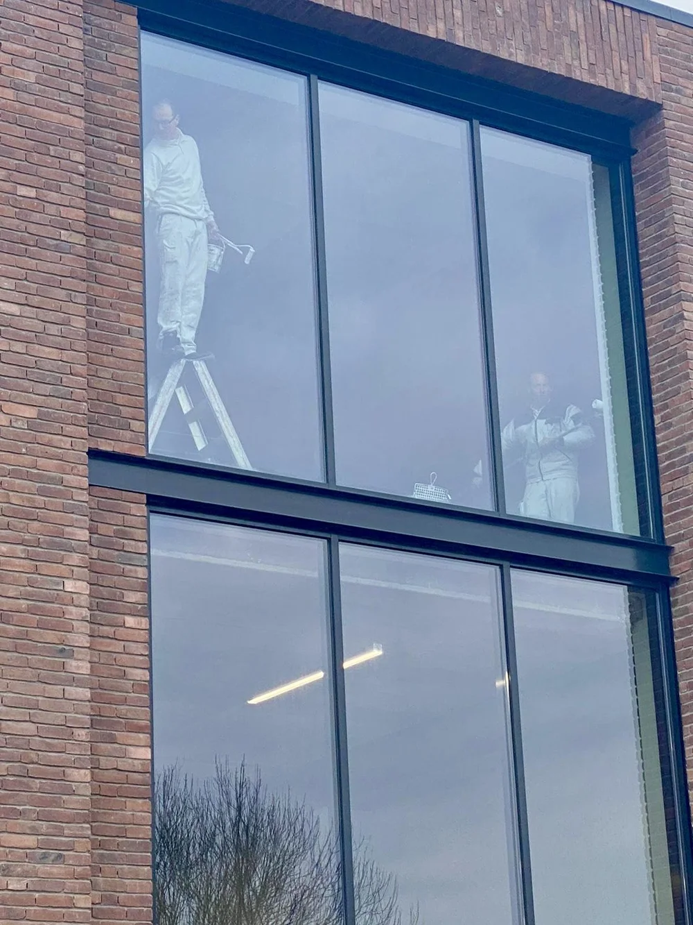 Schilderwerk achter glasgevel van bedrijfspand in Vijfhuizen