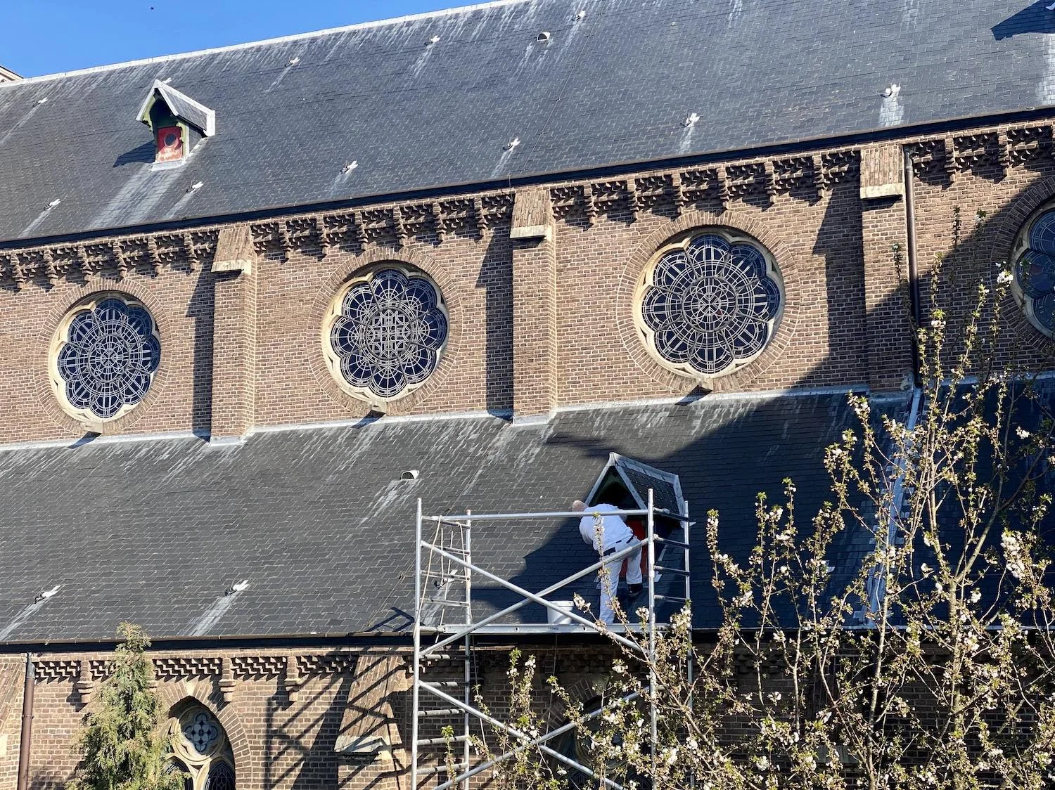 Edward Asseler werkt aan een dakkapel van de Bavo Kerk